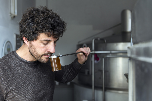 KI generiert: Das Bild zeigt zwei Personen an einem Teichrand beim Fischfang. Eine Person steht im Wasser mit einem Kescher, während die andere Person am Ufer steht.