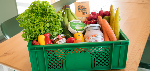 KI generiert: Eine grüne Kiste mit frischem Obst und Gemüse sowie Bioprodukten.