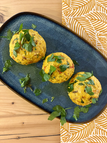 KI-generierte Beschreibung: Hauptinhalt: Gebratene Zucchini mit Kräutern auf einem blauen Teller.