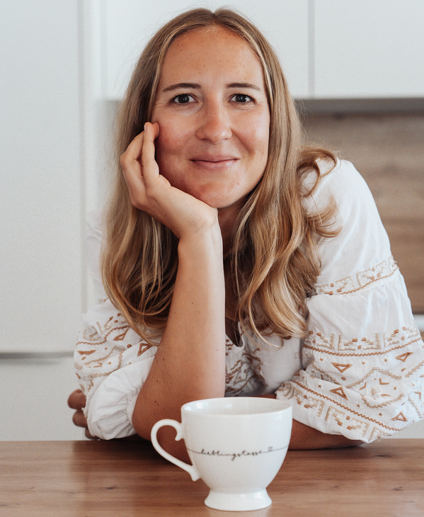 KI-generierte Beschreibung: Hauptinhalt des Bildes: Frau trinkt Kaffee in einem Café.
