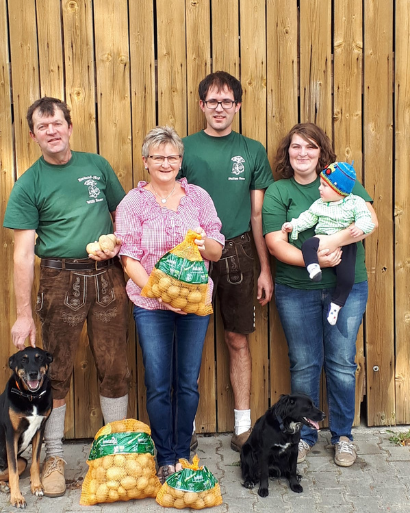 KI generiert: Eine Familie steht auf einem Blumenfeld unter blauem Himmel mit der Sonne im Hintergrund.