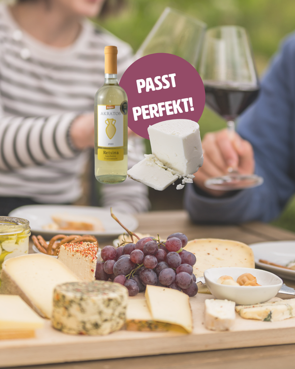 KI generiert: Käseplatte mit Weinflasche, Trauben und Aufschrift "PASST PERFEKT!".