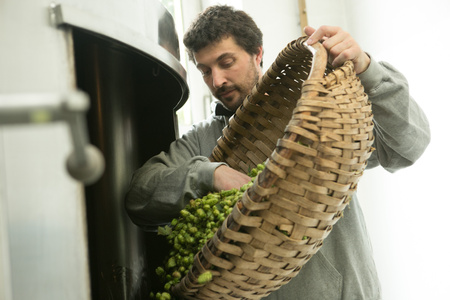 KI generiert: Ein Mann steht lächelnd vor einem Regal mit verschiedenen Flaschen und Produkten, während er weitere Flaschen in seinen Armen hält. Das Bild vermittelt den Eindruck eines Geschäfts oder einer Produktpräsentation.