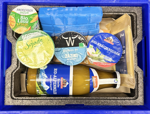 KI generiert: Eine Kühlbox mit Bio-Produkten wie Joghurt, Quark, und Apfelsaft.