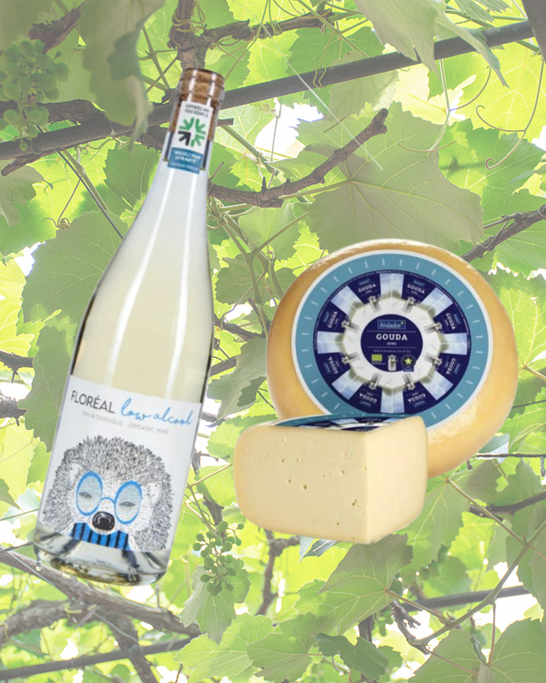 KI generiert: Weinflasche, Käselaib und -stück vor grünen Weinblättern. Text: "FLORÉAL low alcohol" und "GOUDA".