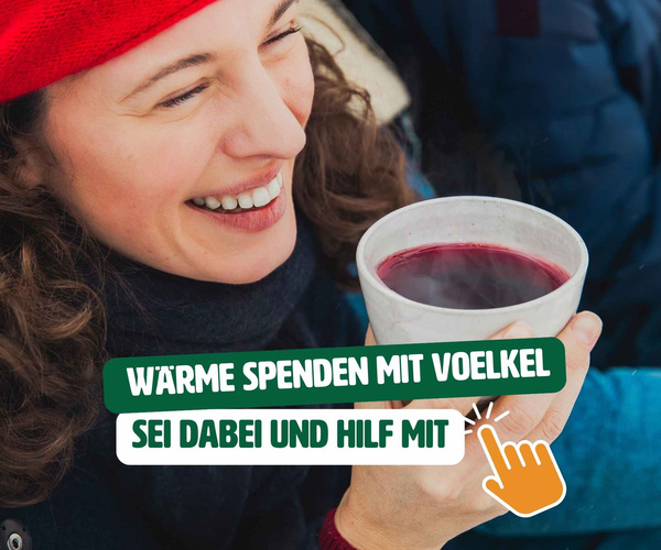 KI generiert: Frau in rotem Hut hält eine Tasse. Text: "Wärme spenden mit Voelkel. Sei dabei und hilf mit."