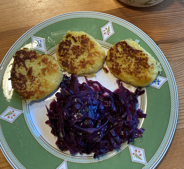 KI generiert: Herzform-Kartoffelklöße und Rotkohl auf einem Teller.
