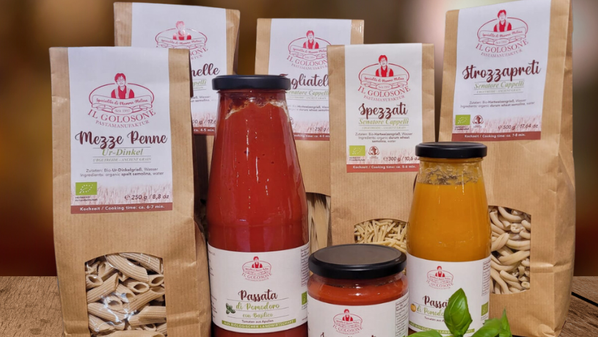 KI generiert: Verschiedene italienische Pastasorten und Saucen von "IL GOLOSONE" auf einem Tisch.