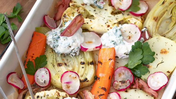 KI generiert: Ein Blech mit gebackenem Gemüse, darunter Karotten, Blumenkohl, Radieschen und Kräuterdip.