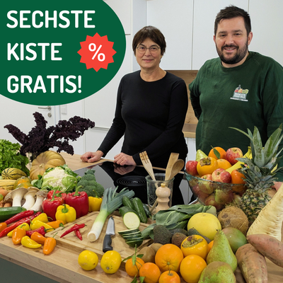 KI generiert: Das Bild zeigt zwei Personen hinter einem Tisch, der mit einer Vielzahl von frischem Obst und Gemüse bedeckt ist. Es gibt ein Werbeschild, das darauf hinweist, dass die sechste Kiste kostenlos ist.