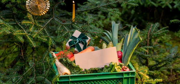 KI generiert: Das Bild zeigt eine grüne Kiste mit frischem Gemüse wie Salat, Blumenkohl und Karotten, die mit einer roten Schleife verziert ist. Der Hauptinhalt des Bildes ist die dekorative Darstellung von Gemüse als Geschenk.