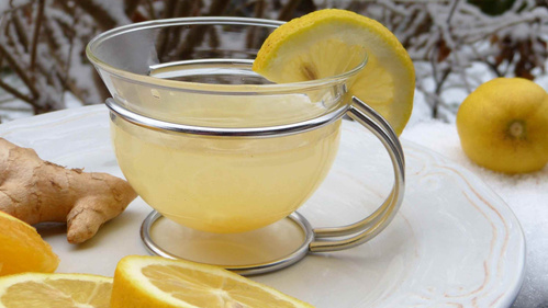 KI generiert: Ein Glas mit Zitronen-Ingwer-Getränk, dekoriert mit Zitronenscheiben und frischem Ingwer.