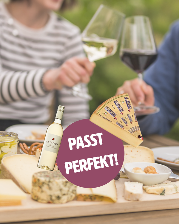 KI generiert: Wein und Käse auf einem Tisch, Text: "PASST PERFEKT!"