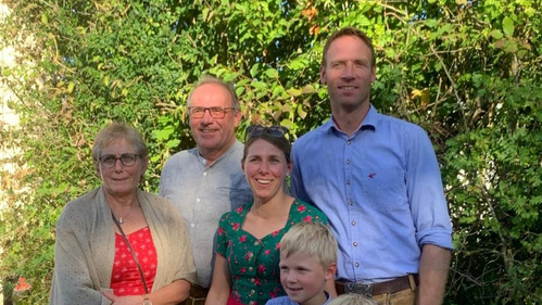 KI generiert: Eine Gruppe von fünf Personen posiert lächelnd im Freien.