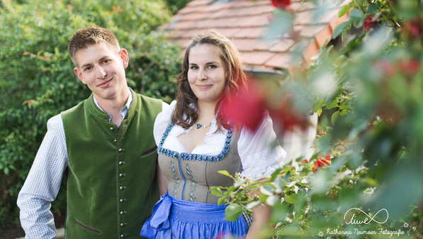 KI generiert: Das Bild zeigt zwei Personen an einem Teichrand beim Fischfang. Eine Person steht im Wasser mit einem Kescher, während die andere Person am Ufer steht.