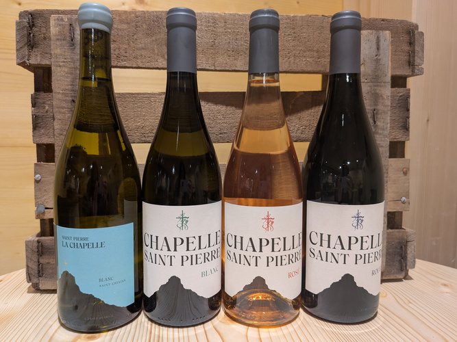 KI generiert: Vier Weinflaschen vor einer Holzkiste. Text: "SAINT PIERRE LA CHAPELLE" und "CHAPELLE SAINT PIERRE".