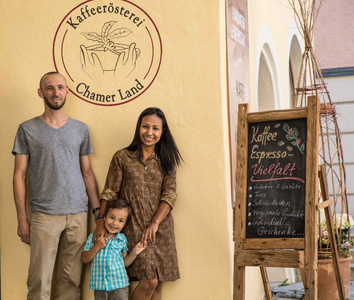 KI generiert: Ein Mann steht lächelnd vor einem Regal mit verschiedenen Flaschen und Produkten, während er weitere Flaschen in seinen Armen hält. Das Bild vermittelt den Eindruck eines Geschäfts oder einer Produktpräsentation.