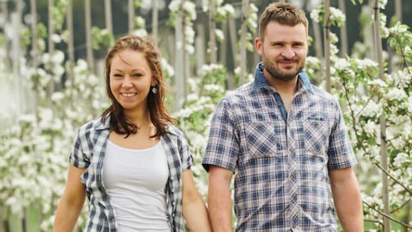 KI generiert: Ein lächelndes Paar spaziert durch einen blühenden Garten.