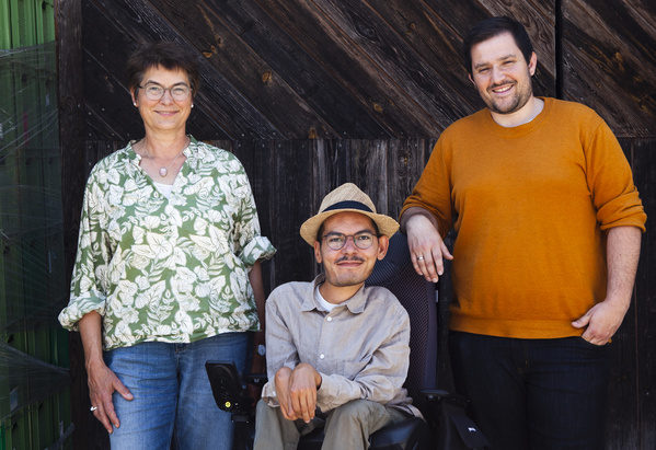 KI generiert: Drei Personen stehen vor einer hölzernen Wand.