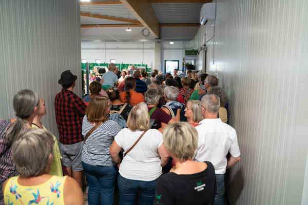 KI generiert: Eine große Gruppe von Menschen steht in einem engen Flur.