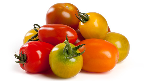 KI generiert: Verschiedene bunte Tomaten in einem Haufen.