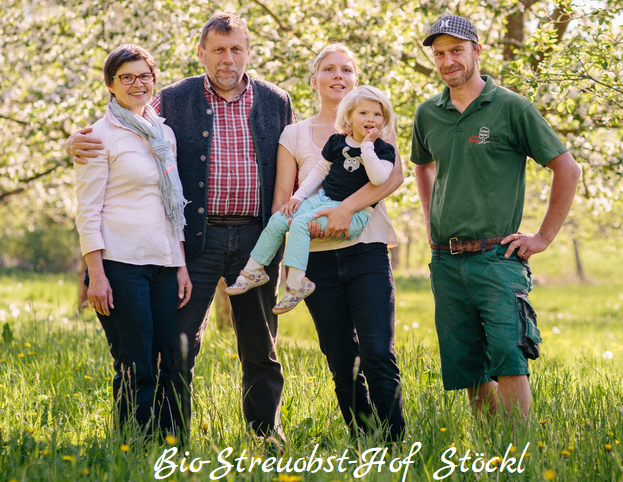 KI generiert: Eine Familie steht auf einer Wiese. Text: „Bio-StreuobstHof Stöckl“.