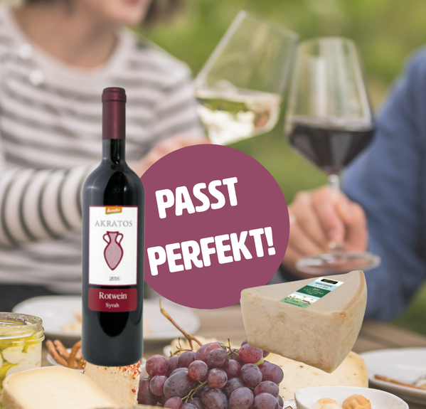 KI generiert: Weinflasche und Käse auf Tisch, Text: "PASST PERFEKT!"
