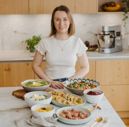 KI generiert: Eine Person steht in einer Küche mit verschiedenen Schalen voller Essen auf dem Tisch.