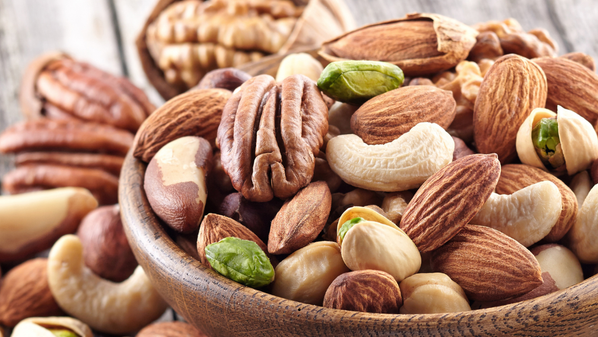 KI generiert: Eine Schale mit gemischten Nüssen, darunter Mandeln, Cashews und Pistazien.