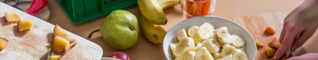 KI generiert: Obst, inklusive Bananen und Birnen, wird auf einem Tisch geschnitten und vorbereitet.